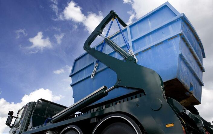 blue dumpsters stacked on top of each other and placed on a truck